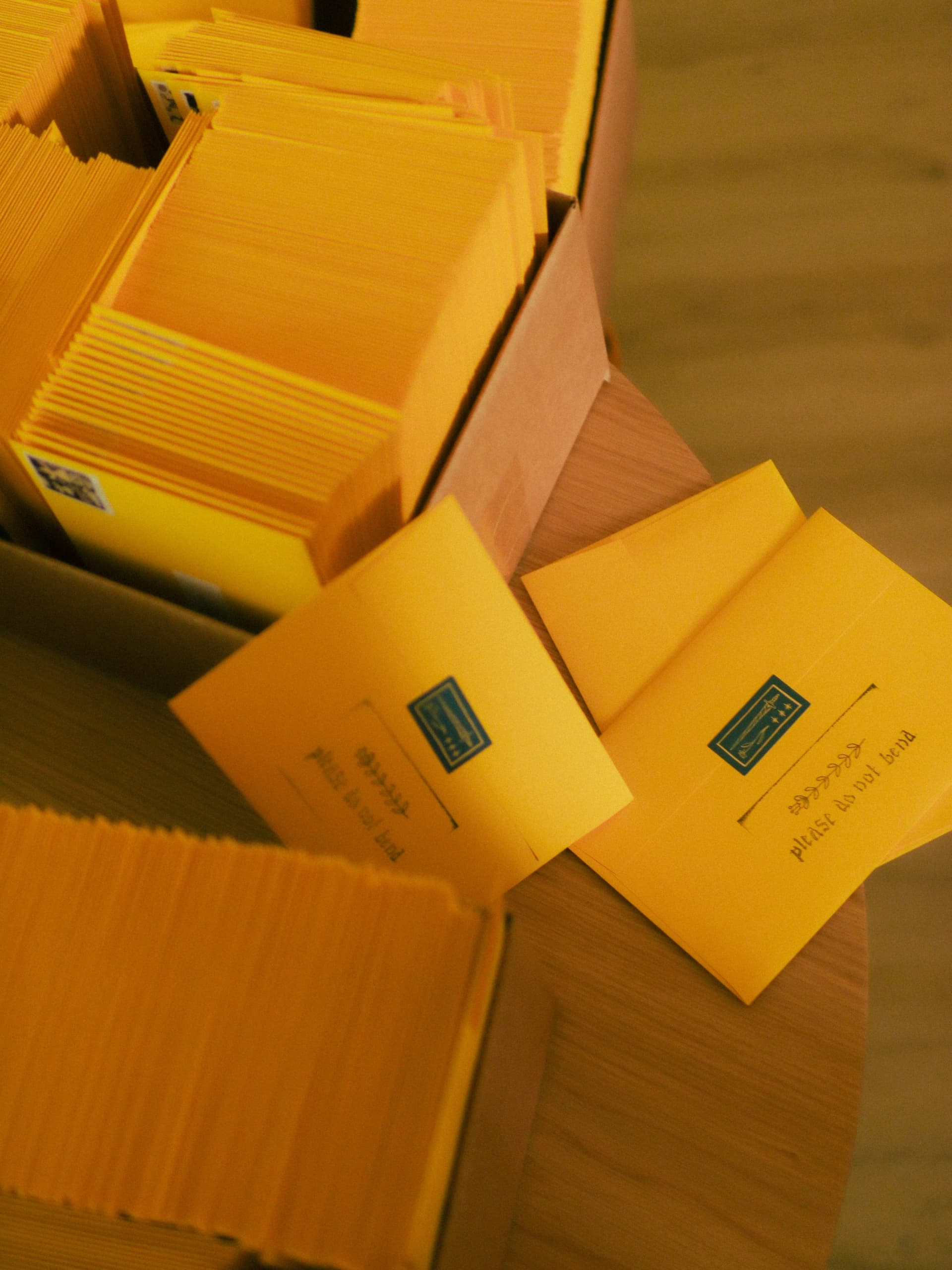 Boxes stacked with yellow mailer envelopes stamped please do not bend